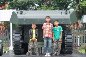 anak-anak bergaya di belakang tank