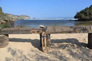 Tempat duduk dari batang pohon kelapa untuk menikmati keindahan Pantai Drini